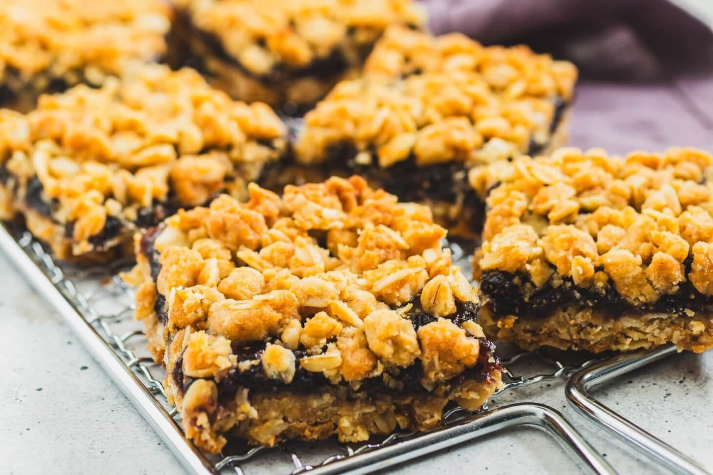 Homemade fig bars stacked on a small wooden board