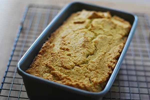 A pan of golden cornbread cut into squares